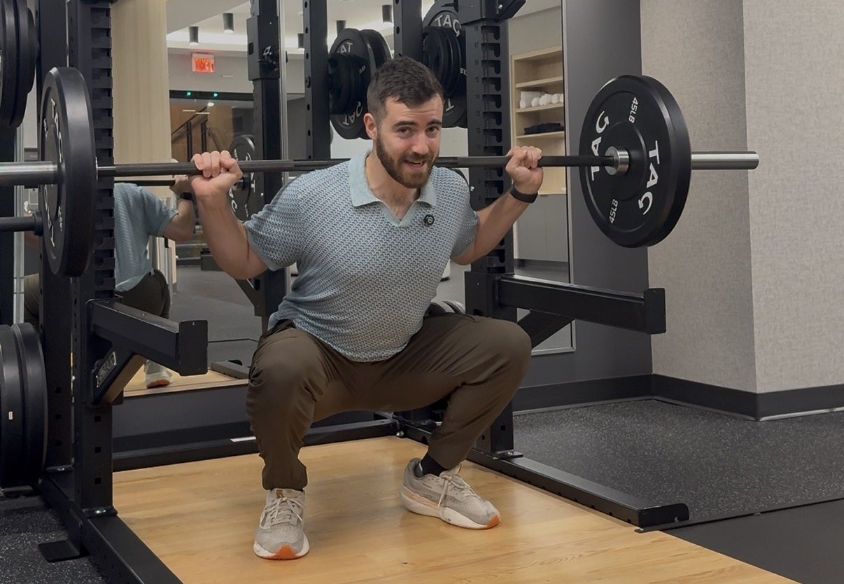 Dr. Brad coaching a client through a squat